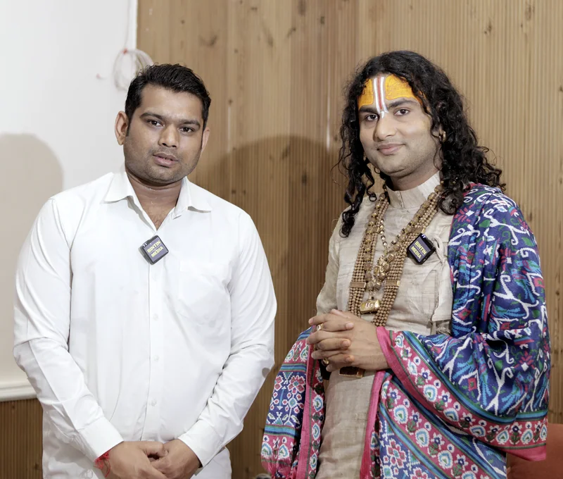 Aniruddhacharya Ji Maharaj with Nitin Vashisth of Bintin Media at their interview, both wearing lapel mics