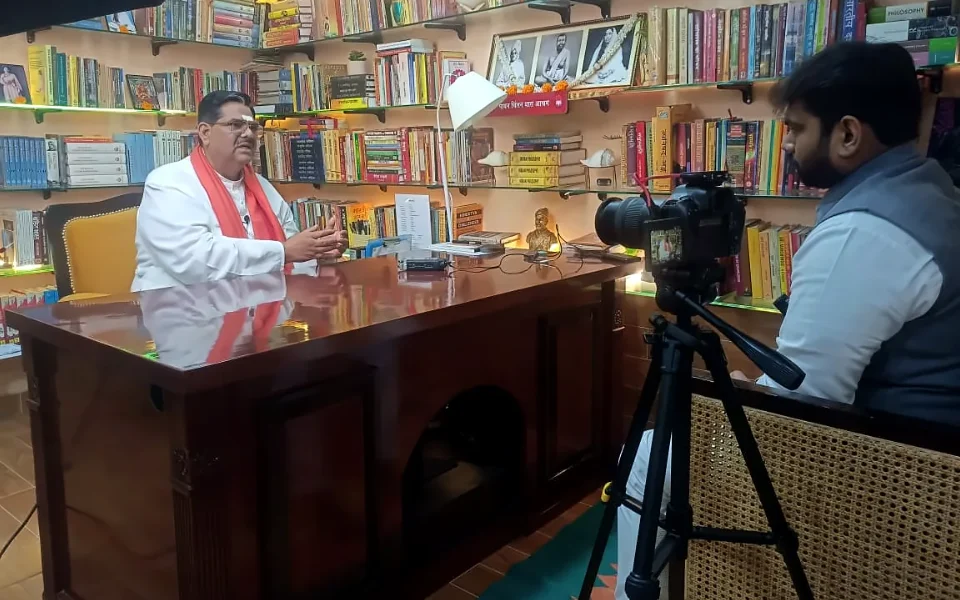 Documentary research shoot in a study lined with books, camera on tripod