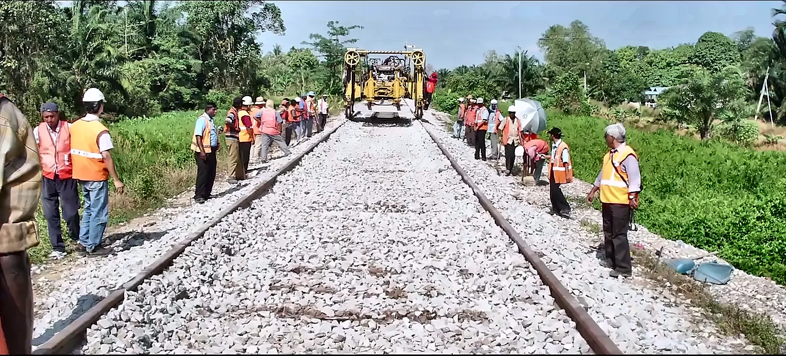 Track gang and supervisors in safety vests on a newly ballasted railway line, from the IRCON corporate film