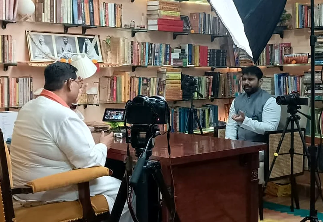 Interview shoot set up in a library with camera and lights after script research by Bintin Media